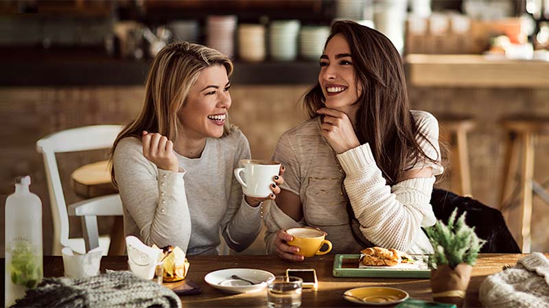 Mujeres sonrientes compartiendo un desayuno 
